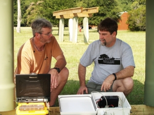 Clark Alexander (right) and research tech Mike Robinson work with light sensors beneath one mock dock. 