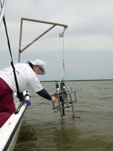 Researcher Kate Doyle lowers a sensor package into the water to measure salinity, temperature and depth.