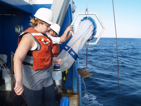 Graduate students Lauren Lamboley and Nick Castellane deploy a plankton net from the Research Vessel Savannah. 